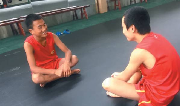 ▲阿坝州马尔康训练馆,小伍(左)和小伙伴聊天。新京报记者 陶若谷 摄